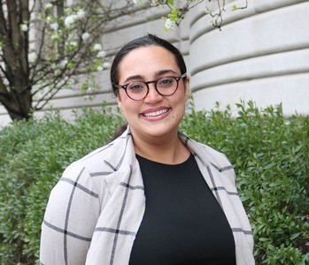 Smiling woman with glasses outside on Columbia's campus.