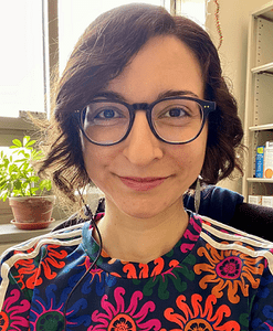 Portrait of smiling woman with glasses, in her office.