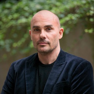 Portrait of man in blazer, outside.