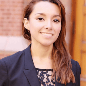 Portrait of woman in business attire, smiling at camera.