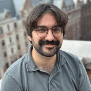 Man in glasses, with beard, smiling from Columbia's campus.